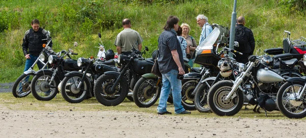 Verschillende vintage motorfietsen, bromfietsen en scooters op een tentoonstelling veld. — Stockfoto