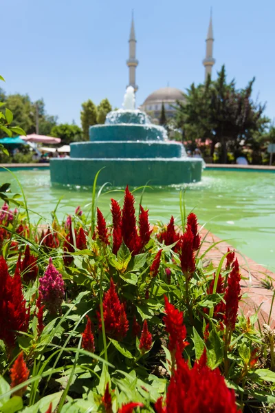 A praça central com uma fonte na aldeia. No fundo Mesquita — Fotografia de Stock