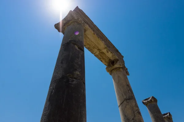 Ancient ruins of Perge on a background of blue sky. Optical glare from the sun. Turkey. — Stock Photo, Image