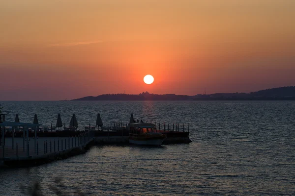 Anlegestelle mit Boot. Sonnenuntergang am Meer. — Stockfoto