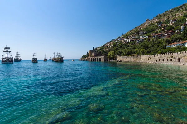 Astillero (Tersane) y las ruinas de una fortaleza medieval (Castillo de Alanya) en la ladera de la montaña . — Foto de Stock