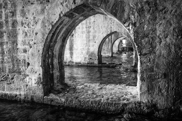 Interiér loděnice (Tersane) v troskách středověké pevnosti (Hrad Alanya). Alanya. Turecko. Černá a bílá. — Stock fotografie