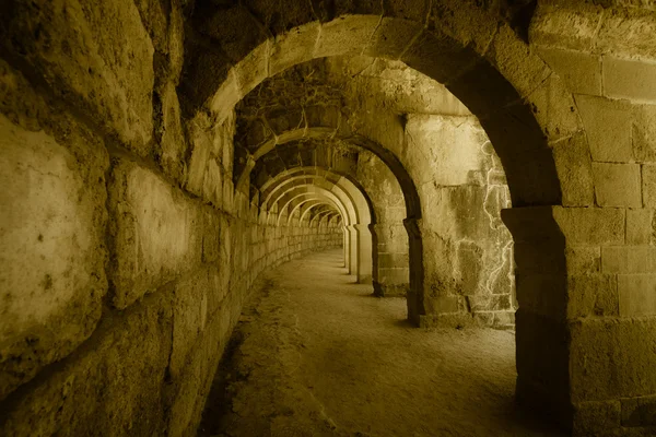 Internal passages in the ancient Roman amphitheater of Aspendos. The province of Antalya. Mediterranean coast of Turkey. Vintage toning. Stylization. — Stock Photo, Image