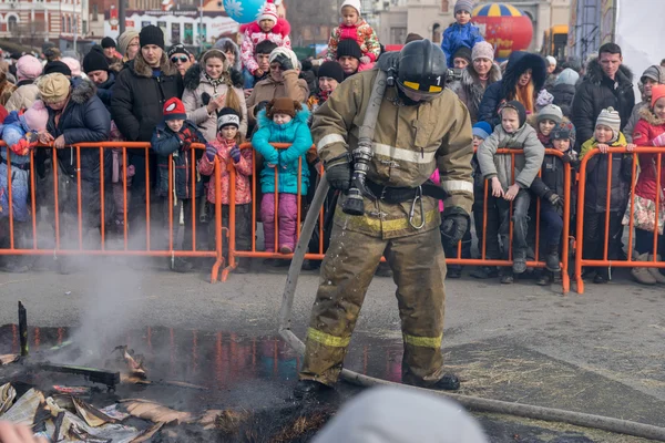 Пожарный тушит чучела Масленицы . — стоковое фото