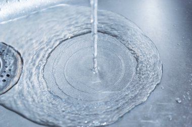 bir mutfak lavabo deliği aşağı akan su.