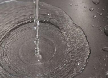 bir mutfak lavabo deliği aşağı akan su.