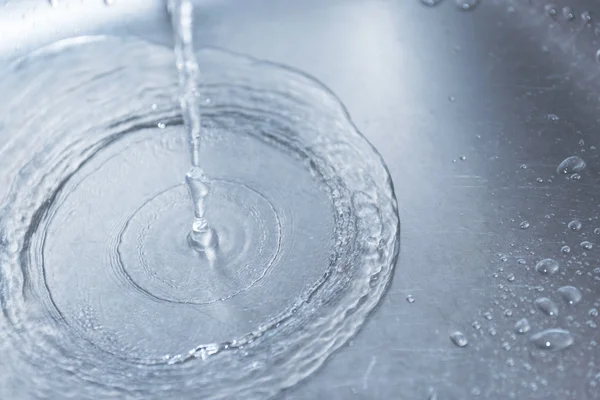 Acqua che scorre lungo il foro in un lavandino della cucina . — Foto Stock