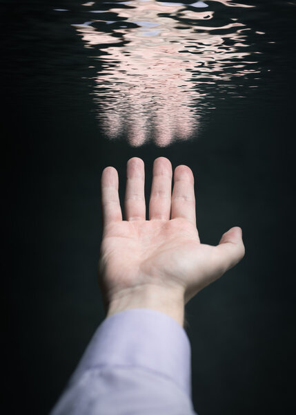 Hand reflected in water surface.