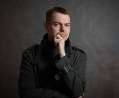 Siyah arka planda ceketli genç bir adam..