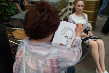 MOSCOW, RUSSIA - 23 Ağustos 2017: Sanatçı genç bir kadının portresini çiziyor.