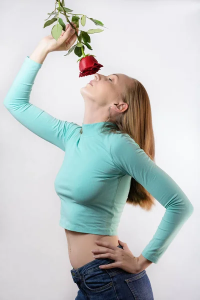 Woman hold one red rose in hand on light background.