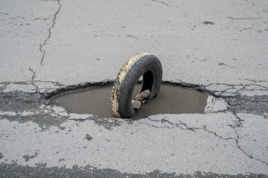 Çukurları ve tekerlekleri olan bozuk bir yol..