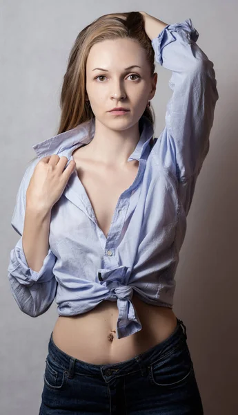 ピンクのシャツに青い目の若い女性の官能的な肖像画 — ストック写真