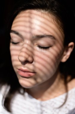 Yüzünde çizgili gölgesi olan güzel genç bir kadın..