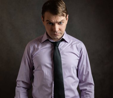 Karanlık arka planda kızgın genç bir adamın portresi..