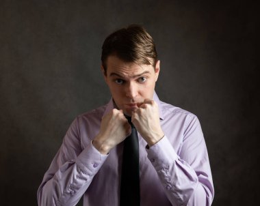 Karanlık arka planda kızgın genç bir adamın portresi..