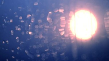 Su cam üzerine bırakır. Odak dışında.