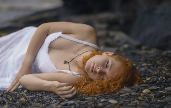 Mooie redhead vrouw op het rotsachtige strand. — Stockfoto