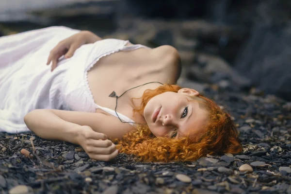 Beautiful woman at the rocky beach.