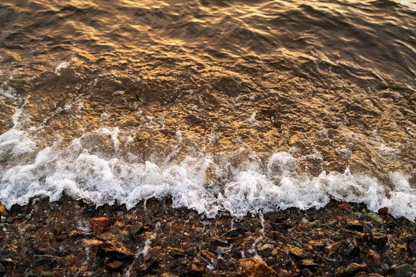 Onde in riva al mare al tramonto . — Foto Stock