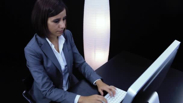 Mujer trabaja en el ordenador y muestra una tarjeta con texto — Vídeo de stock