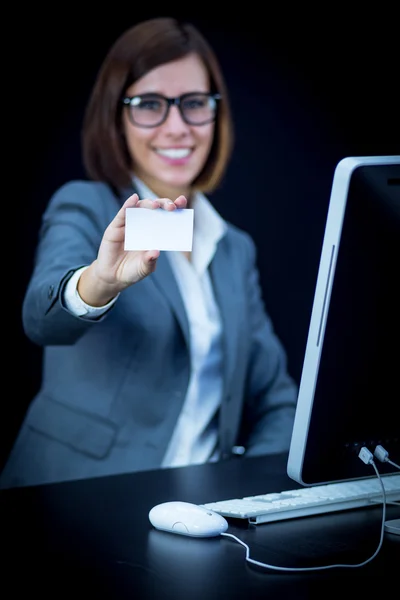 Woman works at the computer and showing a blank card — Stock Photo, Image