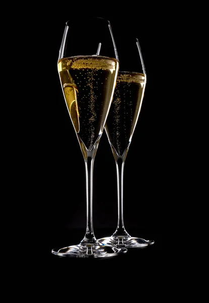 两个精美的水晶香槟长笛 镶满了闪耀的白葡萄酒 背景是黑色的 — 图库照片