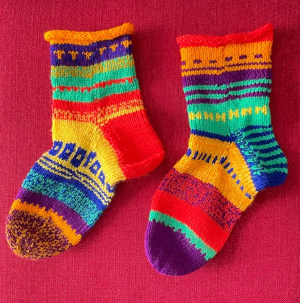 Pair Colorful Handmade Wool Socks Unique Patterns Designs Red Background — Stock Photo, Image