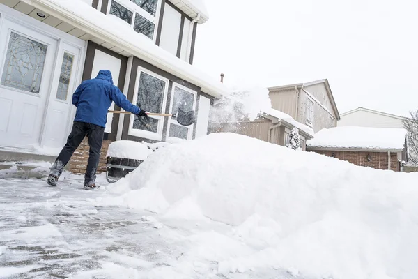 Mann schaufelt Schnee — Stockfoto