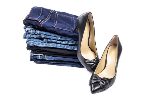 Пачка синих джинсов и туфли на высоком каблуке из чёрной кожи — стоковое фото