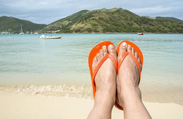 Frau trägt orangefarbene Flip-Flops am Strand — Stockfoto