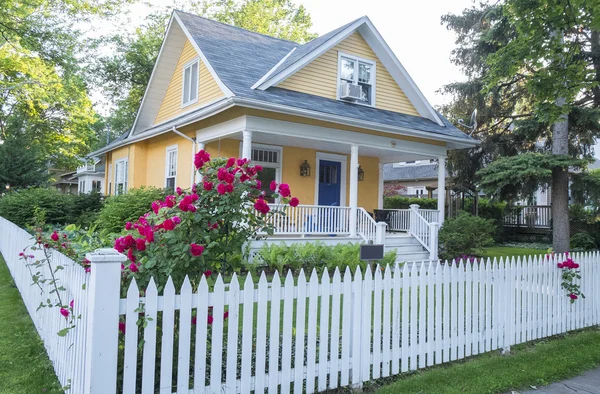 Casa Amarela com Rosa Rosa Bush na Frente Fotografia De Stock