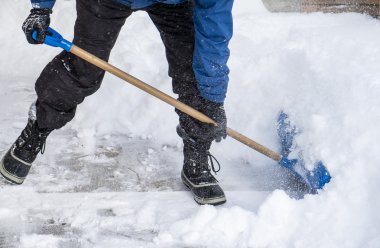 Man Removing Snow with a Shovel clipart