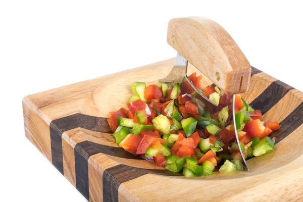 Ulu mes en gehakte rode en groene paprika op een houten blok geïsoleerd — Stockfoto