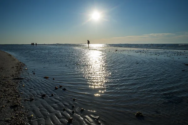 Homem andando na barra de areia durante a maré baixa — Fotografia de Stock