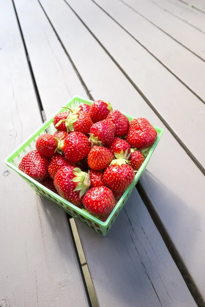 Pint van aardbeien in een groene kunststof mand — Stockfoto