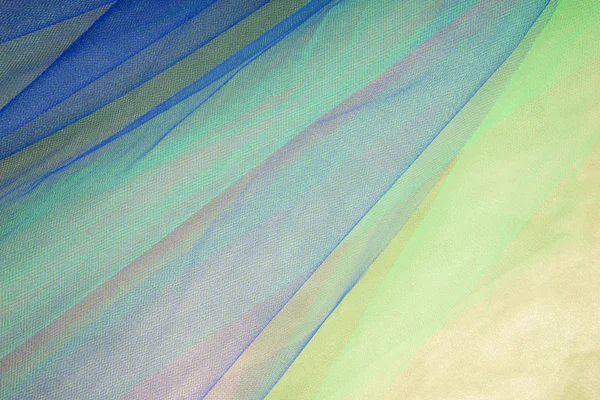 Tulle colorido em fundo de tecido de cetim — Fotografia de Stock