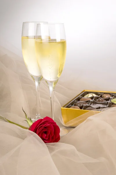 Two Glasses of Champagne, Single Red Rose and an Open Box of Gourmet Chocolates — Stock Photo, Image