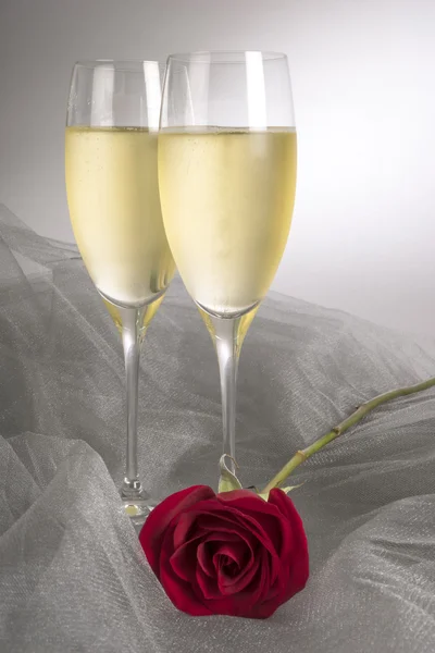 Two Glasses of Champagne and a Single Red Rose — Stock Photo, Image