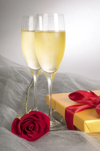 Two Glasses of Champagne with One Single Red Rose and Box of Gourmet Chocolates — Stock Photo, Image