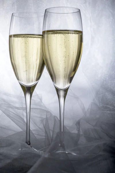 Dvě sklenice šampaňského na šedém pozadí — Stock fotografie