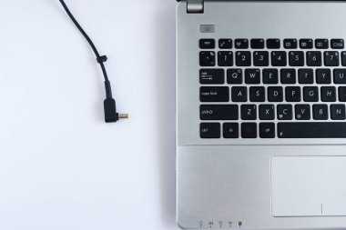 Beyaz arka planda dizüstü bilgisayarın güç kablosu şarjı. Üst Görünüm