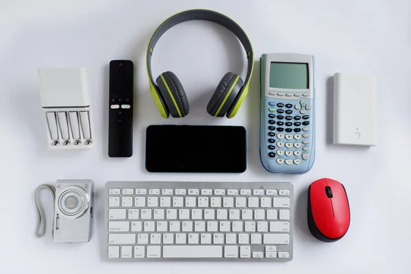 Smartphone with Headphones and Scientific calculator and other electronic gadgets on White background, Reuse and Recycle concept, Top view.