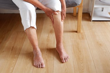 Varisli ya da osteoartritten muzdarip bacağı olan yaşlı Asyalı bir kadın, yaşlıların çeşitli hastalıkları ve sağlıklı yaşam konsepti.