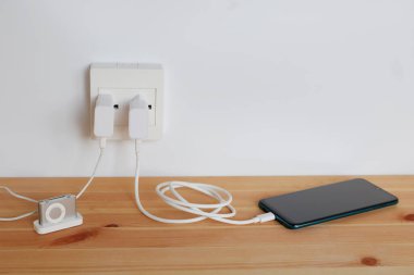 Elektrik prizine, akıllı telefonların adaptör kablosu şarj aletleri, mp3 çaları, ahşap zemine takın.