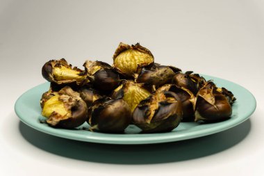 Kestaneler tabakta ateşte pişiyor.