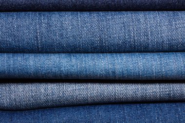 Moda mağazasında katlanmış kot pantolonun yakın plan çekimi. Alışveriş ve giyim endüstrisi kavramları.