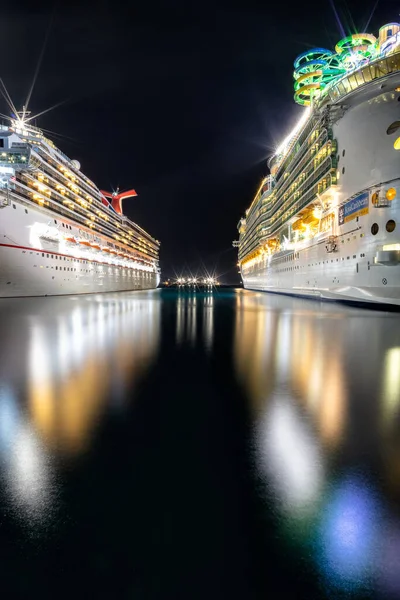 ナッソー バハマ 8月24 2019 夜にプリンスジョージ ワーフでカーニバル リバティとマリナー シーのクルーズ船の肖像画サイズのショット 手前の水の中の豪華な反射 — ストック写真