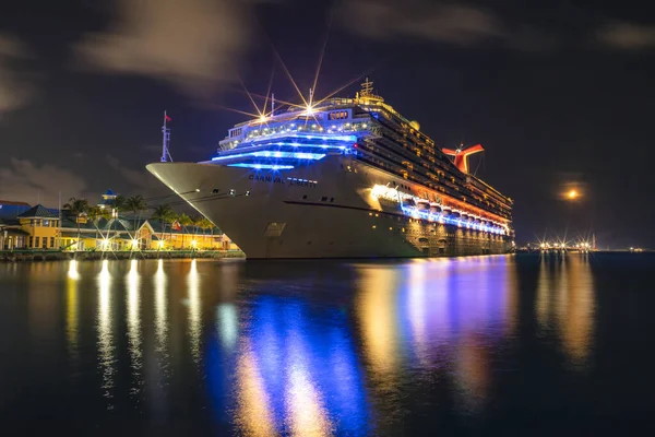 巴哈马拿骚 2019年6月8日 美丽的嘉年华自由号游轮停泊在乔治王子码头 Prince George Wharf 船舶的华丽倒影 港口的灯光在港湾水面上的前景色 图库照片