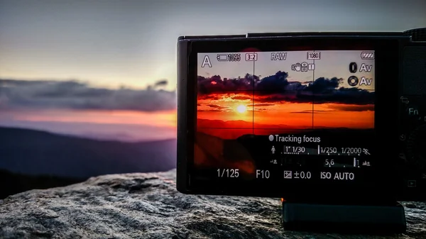 Λαμβάνοντας sunset photo με μια φωτογραφική μηχανή στα βουνά — Φωτογραφία Αρχείου